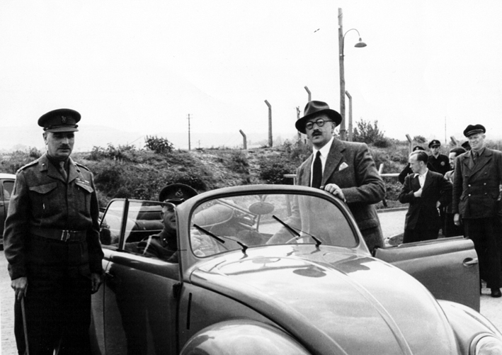 Ivan Hirst (individuo com óculos), alguns oficiais, trabalhadores da VW na retaguarda, e um dos primeiros carochas a ser produzidos após 1945